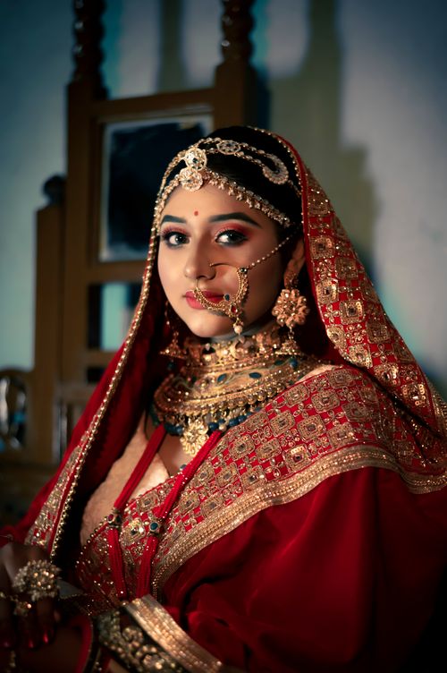 Free Portrait of an Indian bride in traditional red attire adorned with intricate jewelry, exuding elegance and grace. Stock Photo