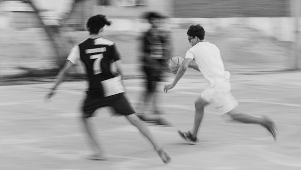 A dynamic black and white image of teenagers playing a fast-paced basketball game in Brazil.