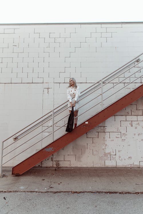 Portrait of Blond Hair Woman Standing on Stairs