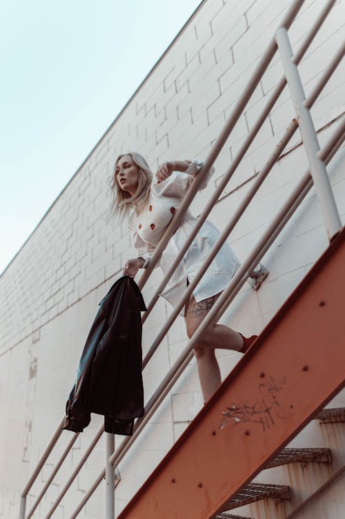 Free Portrait of Blond Hair Woman in Dress Standing on Stairs Stock Photo