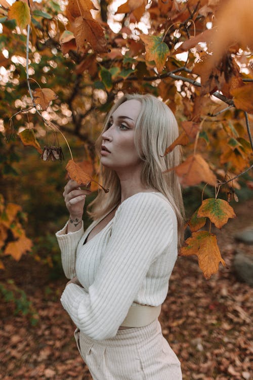 Portrait of Woman Touching Autumn Leaves