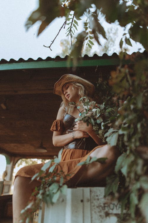 Portrait of Sitting Blond Hair Woman Holding Flowers