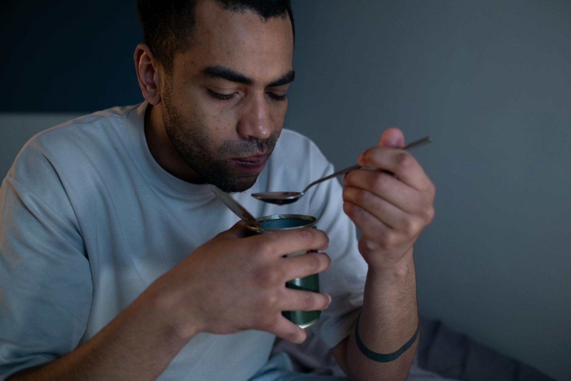 Man Wearing White Shirt Eating Canned Food