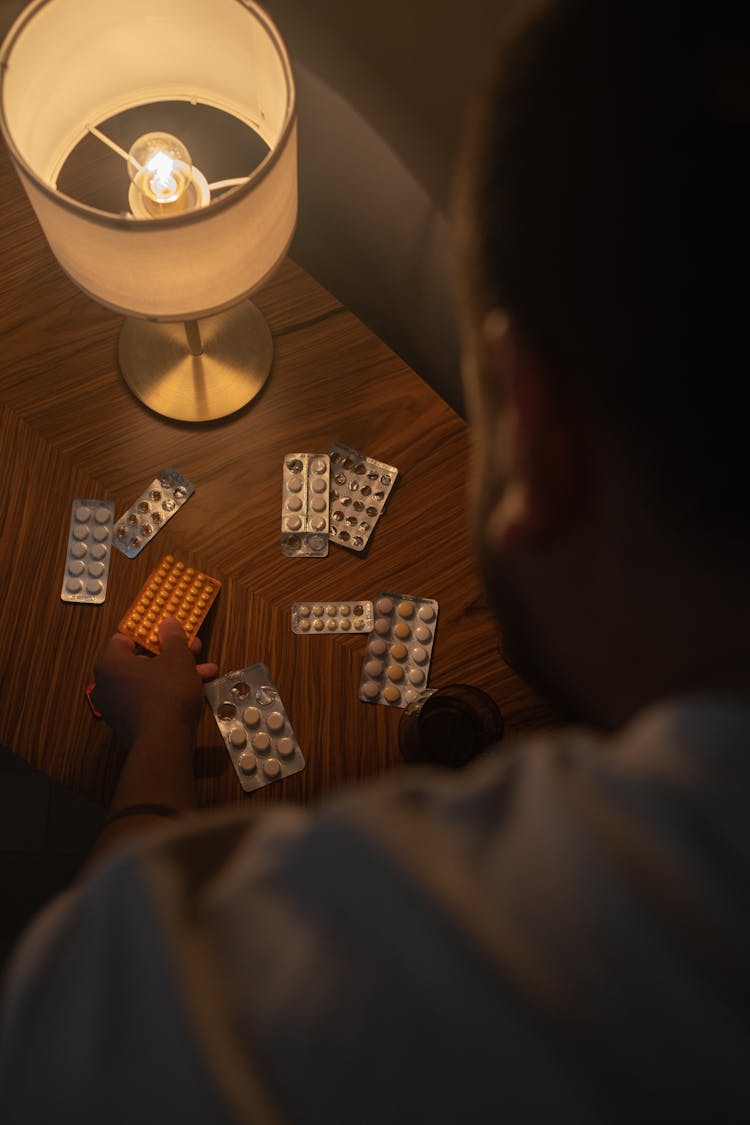 Man Taking Pills From The Table