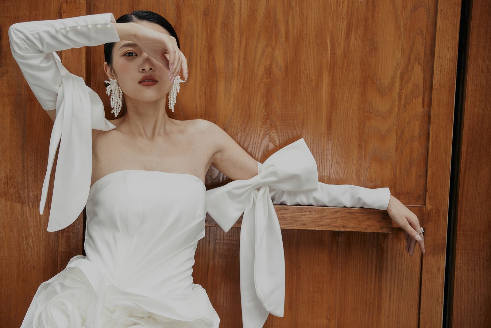 An elegant woman in a white off-the-shoulder dress — bare shoulders, summer 2026's neckline