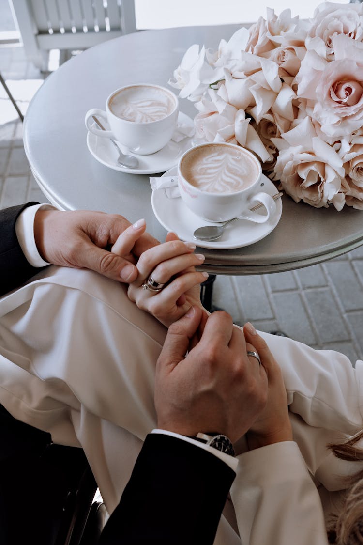 Bride And Groom At Table With Coffee And Bouquet