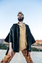 A Bearded Man Wearing a Printed Shirt and an Overcoat