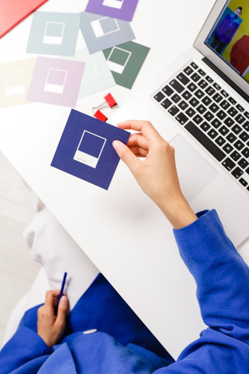 Free Woman in Blue Jacket Holding Paper Card in Hand Stock Photo