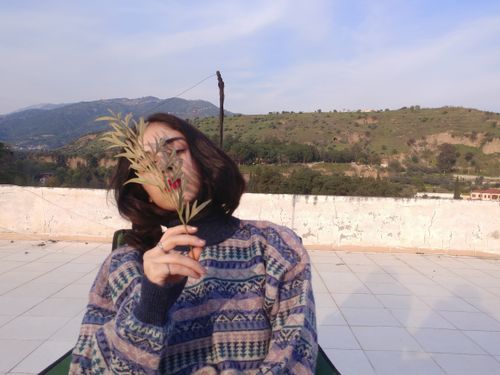 Free Woman sitting outdoors covering face with leaves, in Aydın, Turkey. Stock Photo