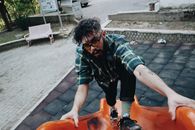 A Man in Checkered Shirt Climbing a Slide
