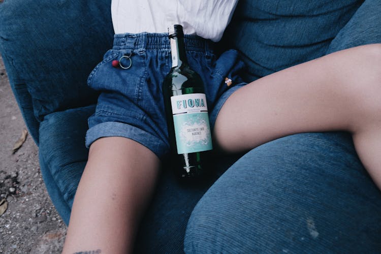 A Bottle Of Liquor Between A Person's Legs