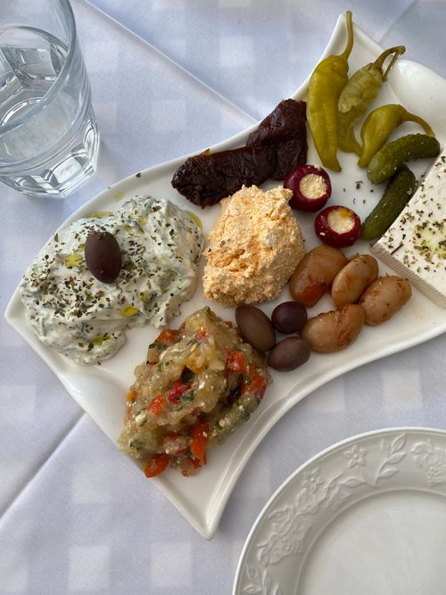 Free Colorful Mediterranean platter with olives, cheese, and peppers on a white tablecloth setting in Moscow. Stock Photo