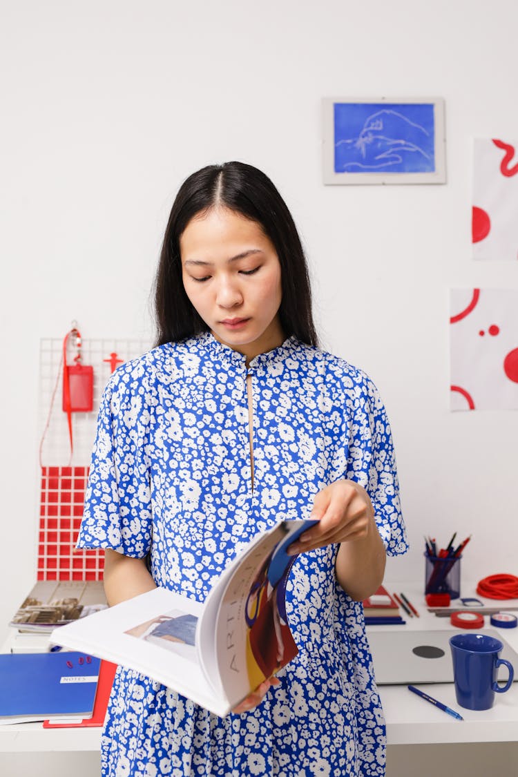 Woman In Blue Dress Reading Magazine In Home Office