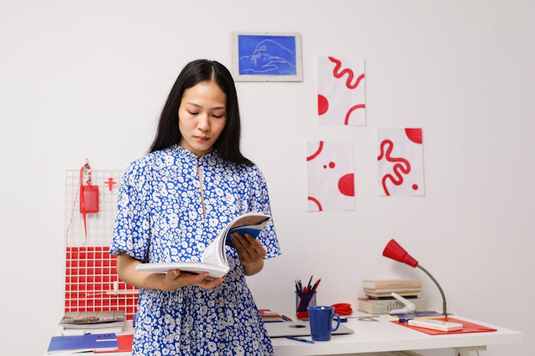 Woman In Blue Dress Reading Magazine In Home Office