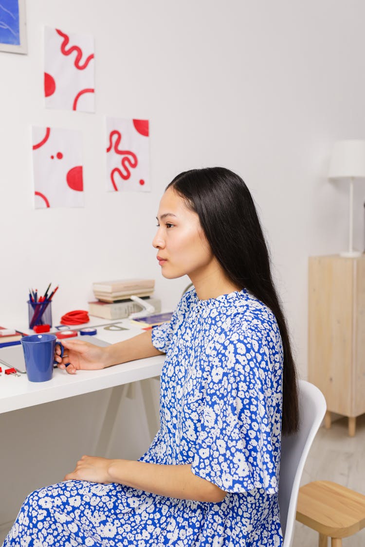 Woman In Blue Dress Drinking Coffee In Home Office