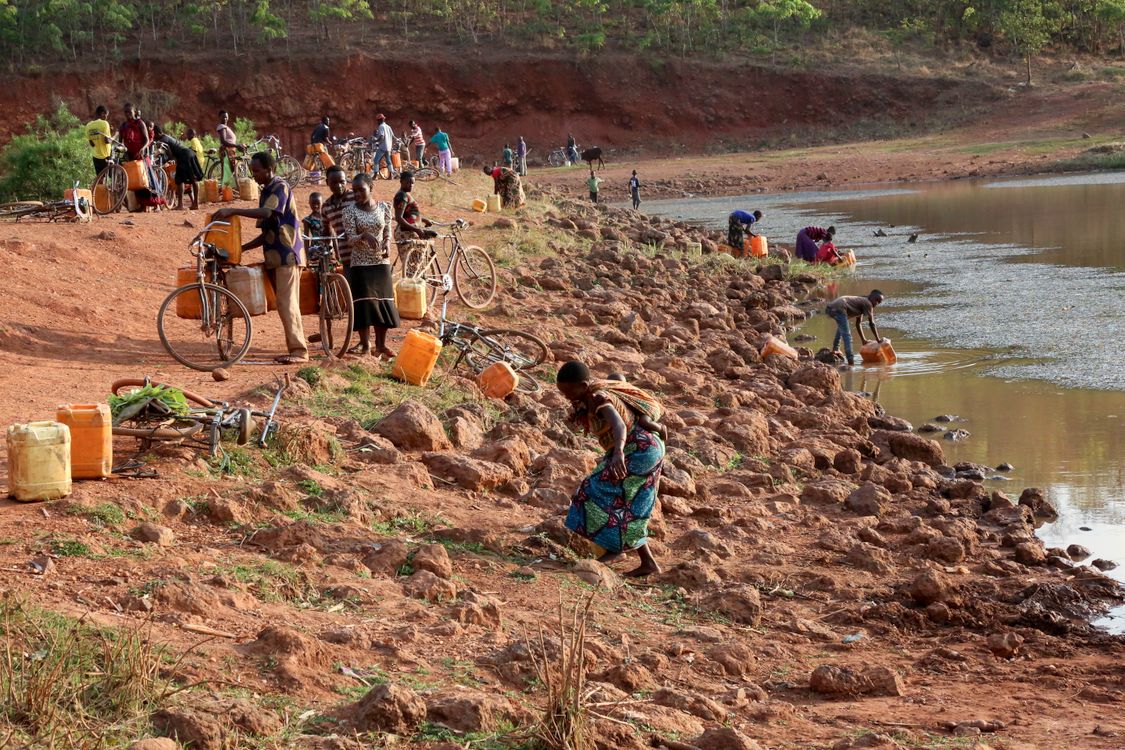 People getting Water on a Riverside · Free Stock Photo