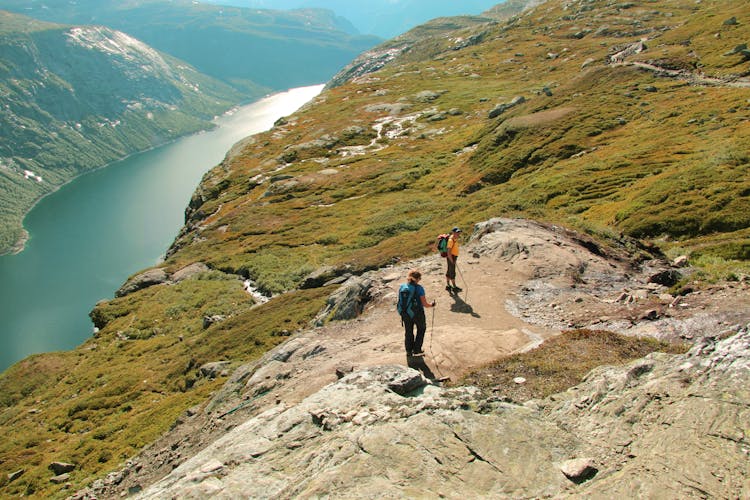 People Hiking On Hills Near River