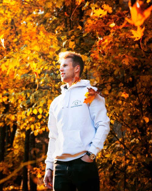 Man in White Hoodie Standing Near a Tree