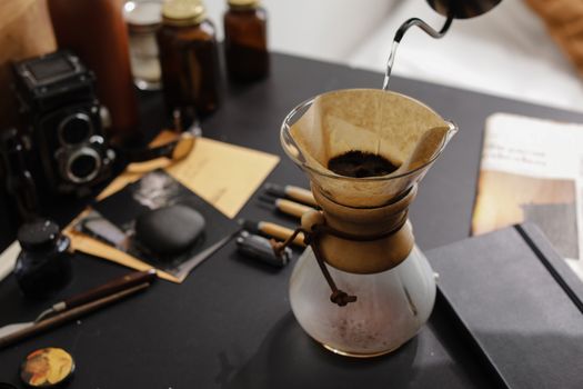 Artistic vision of brewing coffee using a Chemex, featuring a classic camera and cozy setting.