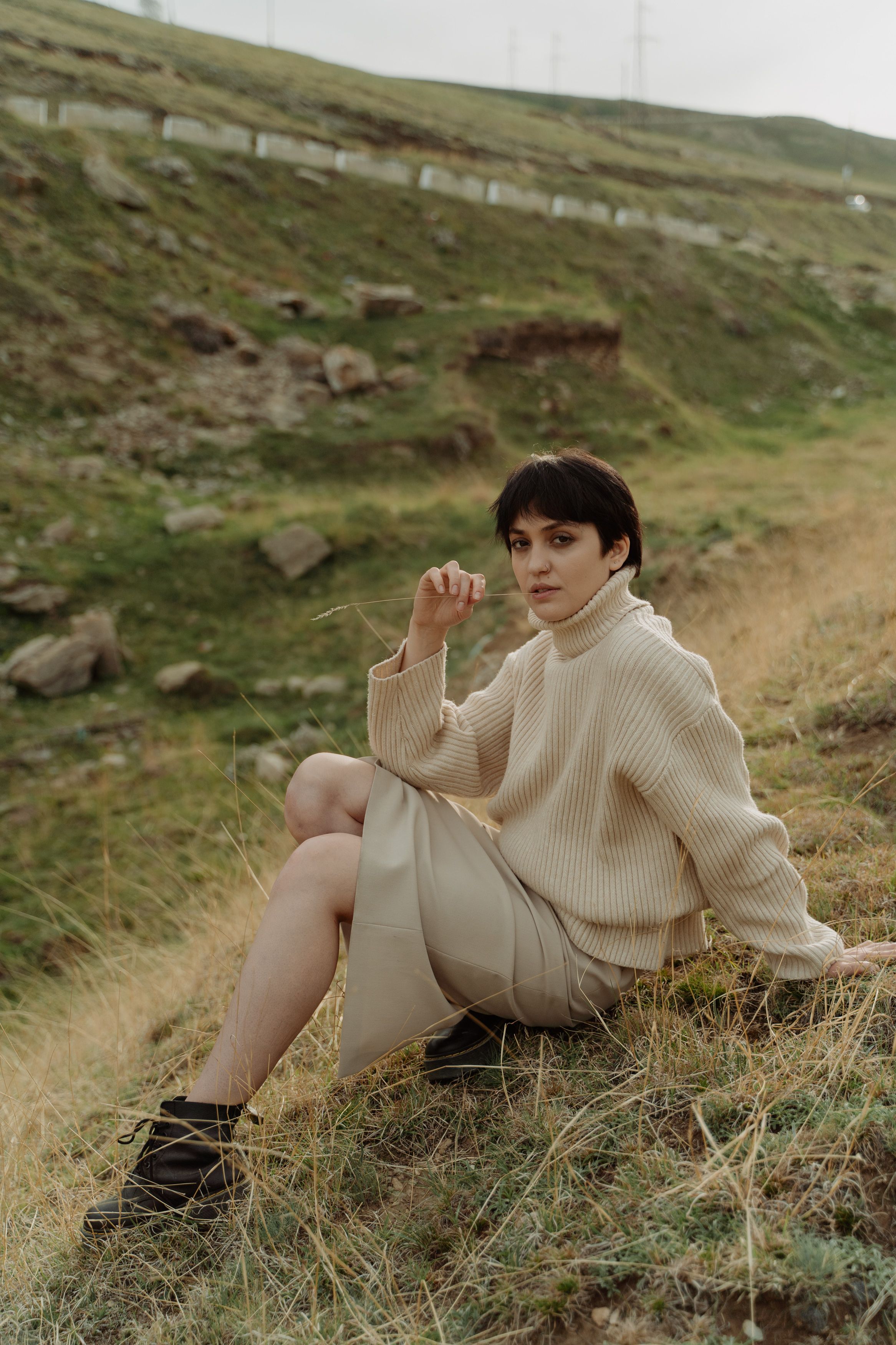 Photo of a Woman in a Beige Sweater Sitting on Grass · Free Stock Photo