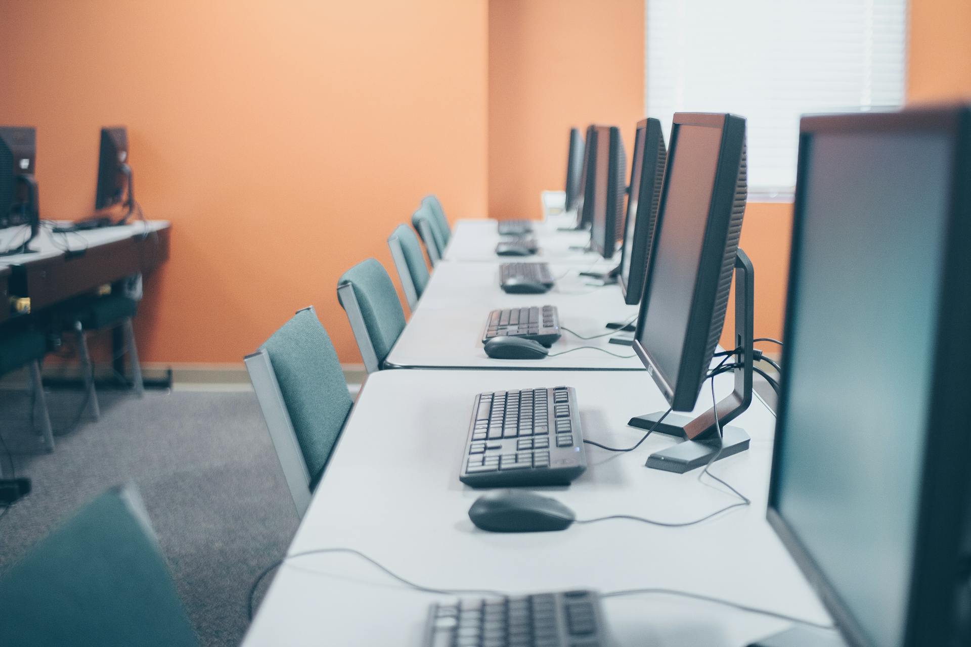 A modern office setup featuring a row of desktops with keyboards and mice, ready for professional use.