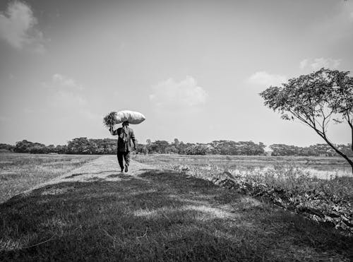 Grayscale Photo of a Farmer with Sack on his Head