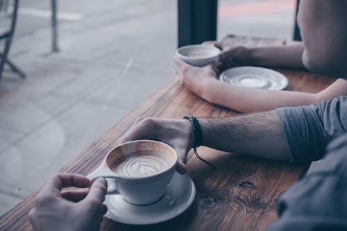 Photo Of Person Holding Cup Of Coffee Latte