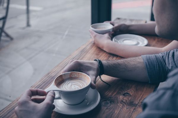 Two people relaxing with cups of coffee