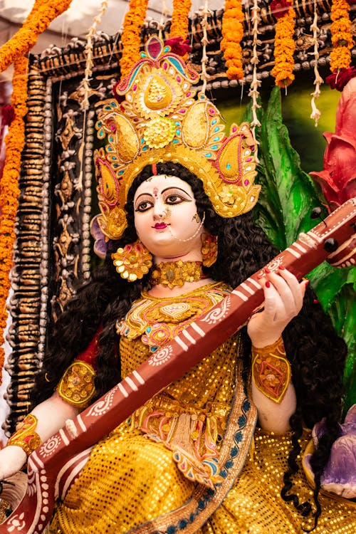 Free Durga Puja Holding a Red Musical Instrument Stock Photo