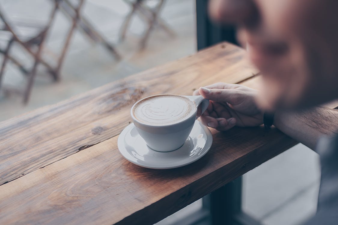 Personne Tenant Une Tasse Blanche Remplie De Café