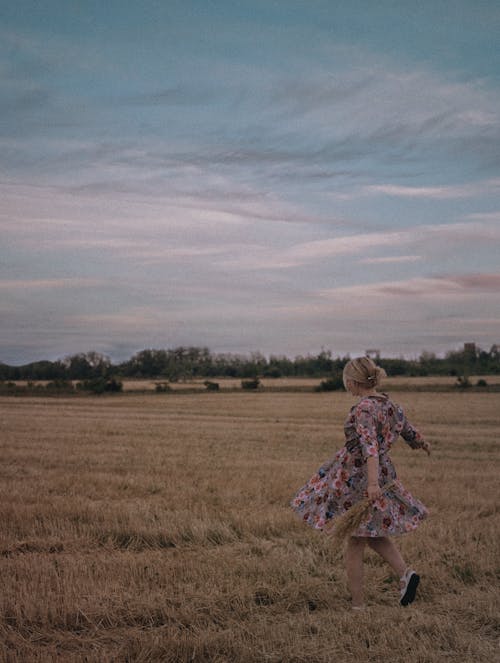 Woman Running in Field in Countryside