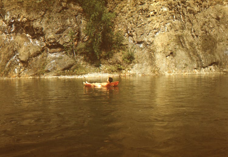 A Man Lying On An Inflatable Floater In The Middle Of The Sea