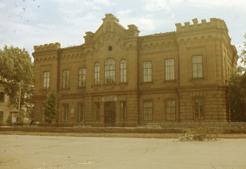 A sepia-toned image of an old brick building with vintage architecture.