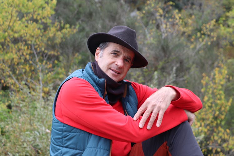 Middle-aged Man In Fedora Hat And Blue Vest And A Red Sweater 