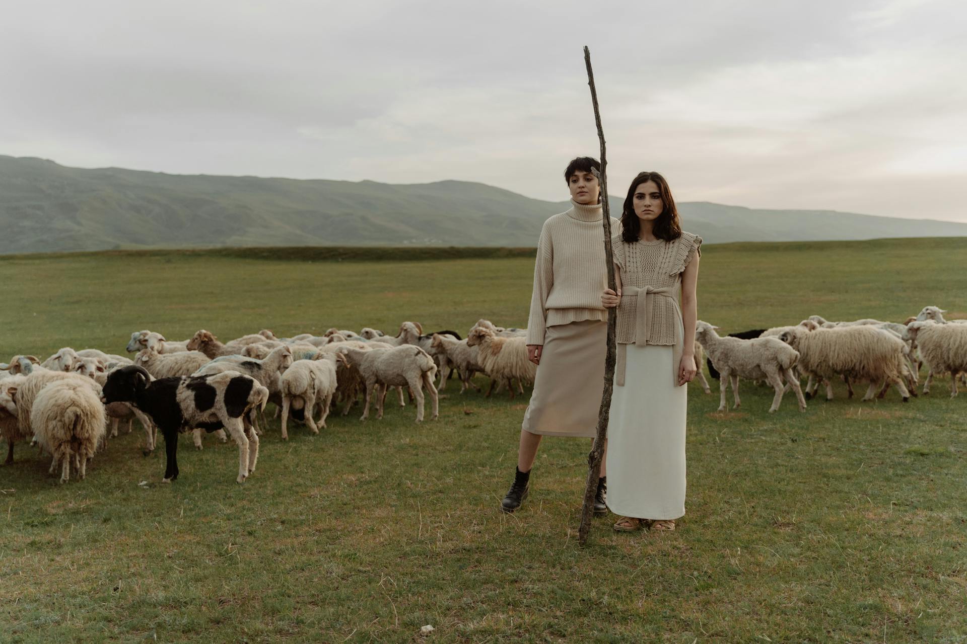 Female Shepherd in Beige Clothing near Sheeps