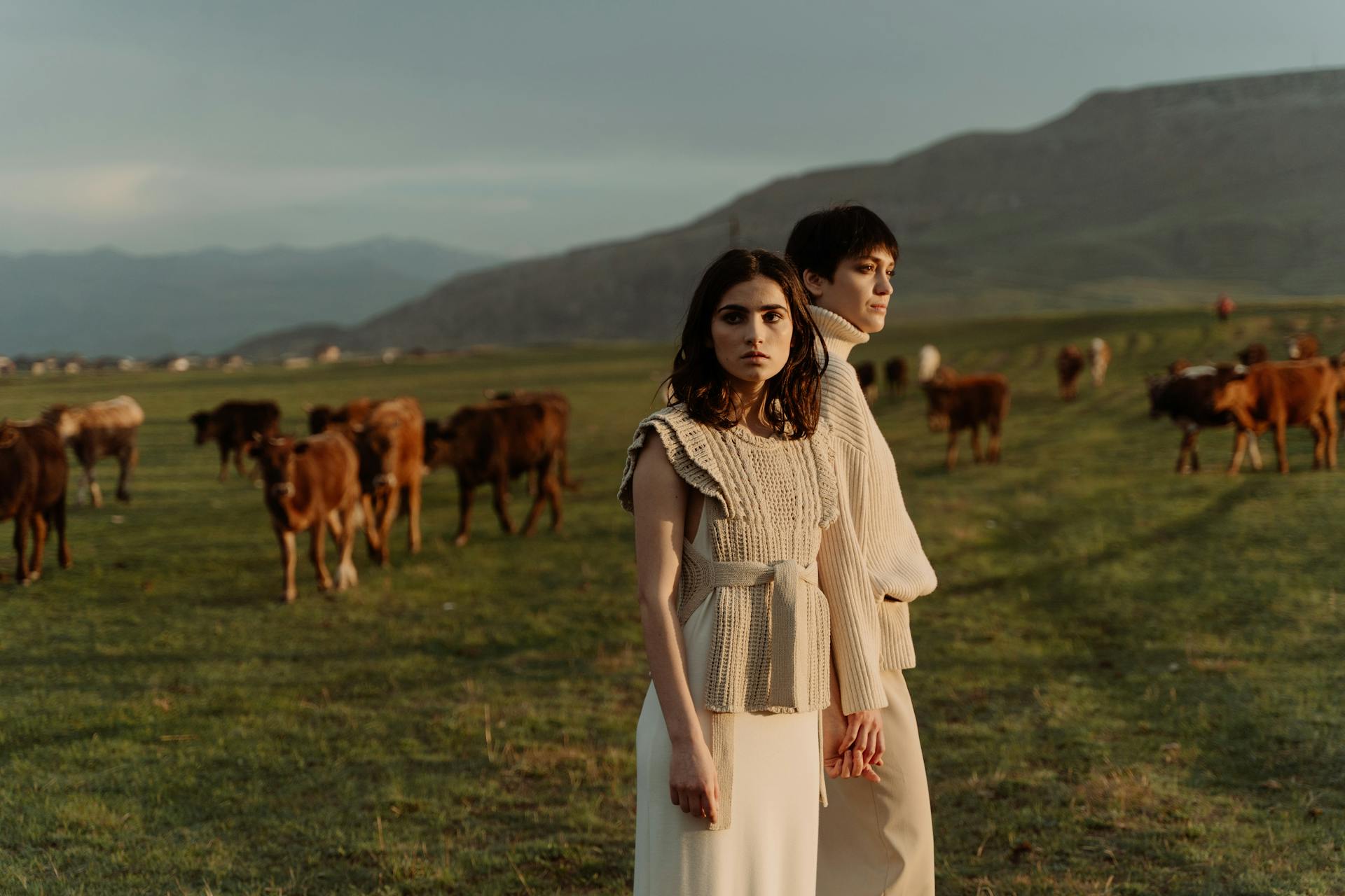 Female Shepherds in Beige Clothing near Cows