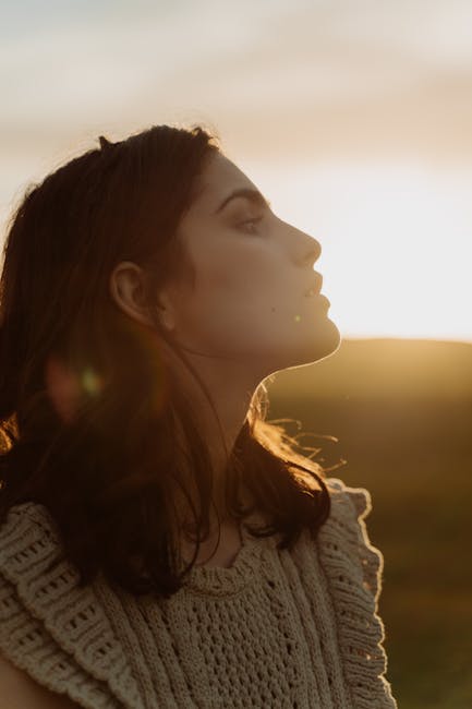 A serene side profile portrait of a woman at sunset highlighting natural beauty and tranquility.