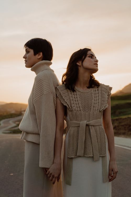 Free Two women in beige knitted outfits pose outdoors at sunset, exuding style and grace. Stock Photo