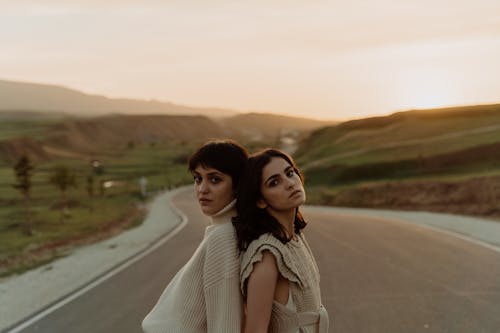 Stylish Women in Beige Clothing standing Back to Back 