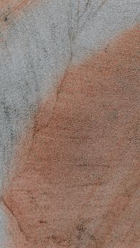 Close-up view of a textured stone surface in earthy hues.