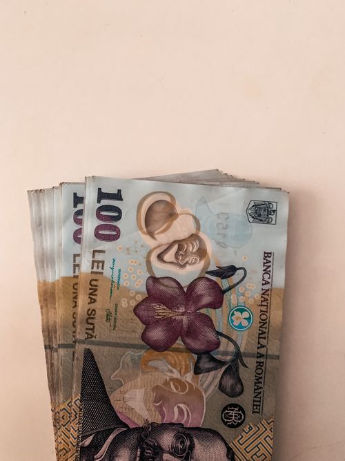 Free High-quality macro image of multiple Romanian Leu banknotes spread on a white surface, showcasing currency details. Stock Photo