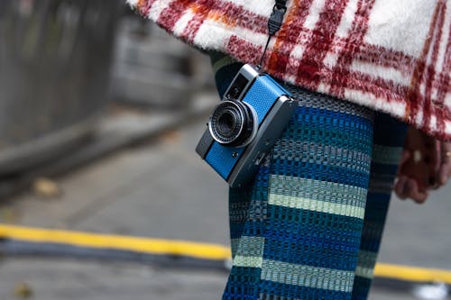 An Analog Camera Hanging on a Person Body