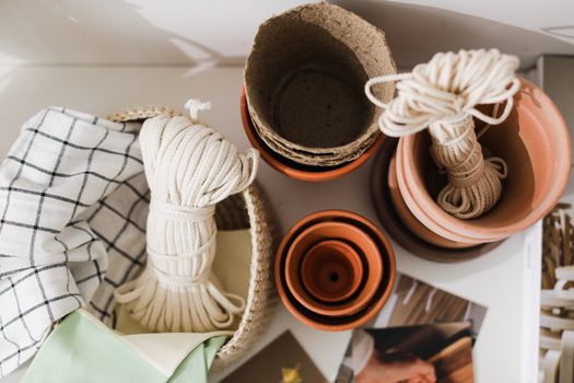 Top view of gardening supplies including flower pots and ropes arranged with textiles.