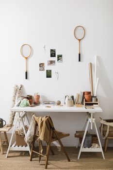 Artistic workspace with badminton rackets, clay pots, and creative decor.