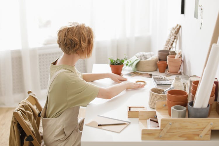 Redhead Woman Sitting At A Desk In A Bright Interior