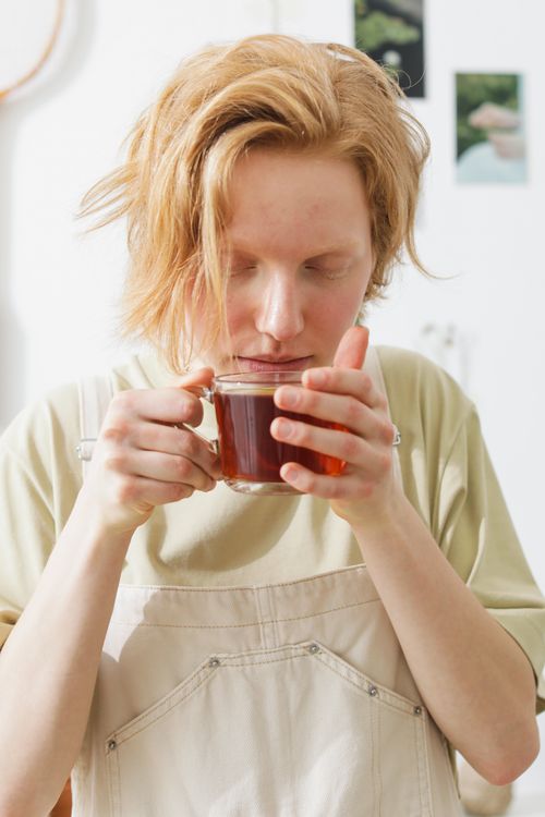 Free A caucasian woman savoring tea, captured in a bright indoor scene, exudes tranquility. Stock Photo