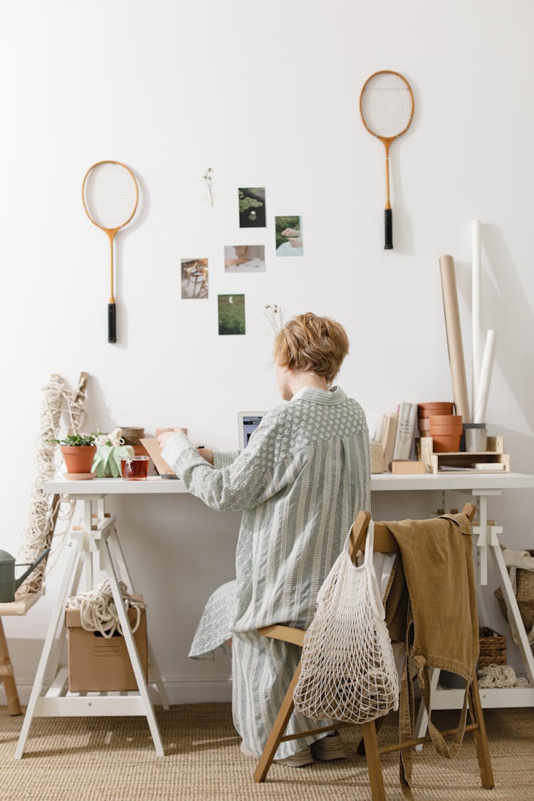 Woman In Pajamas Sitting At Desk In Room