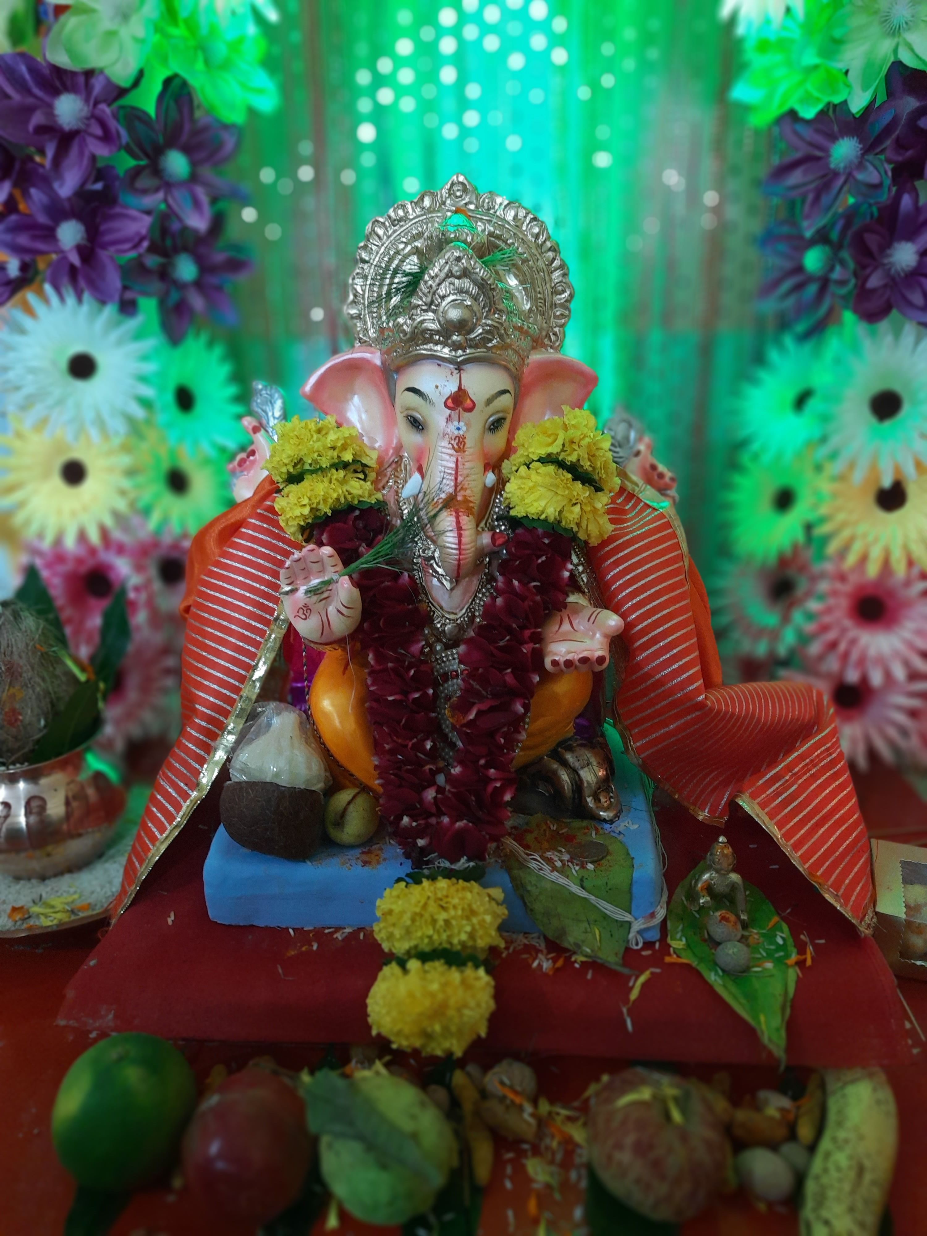 A colorful Ganesh idol adorned with flowers and sweets, capturing the essence of a Hindu festival in Mumbai, India.