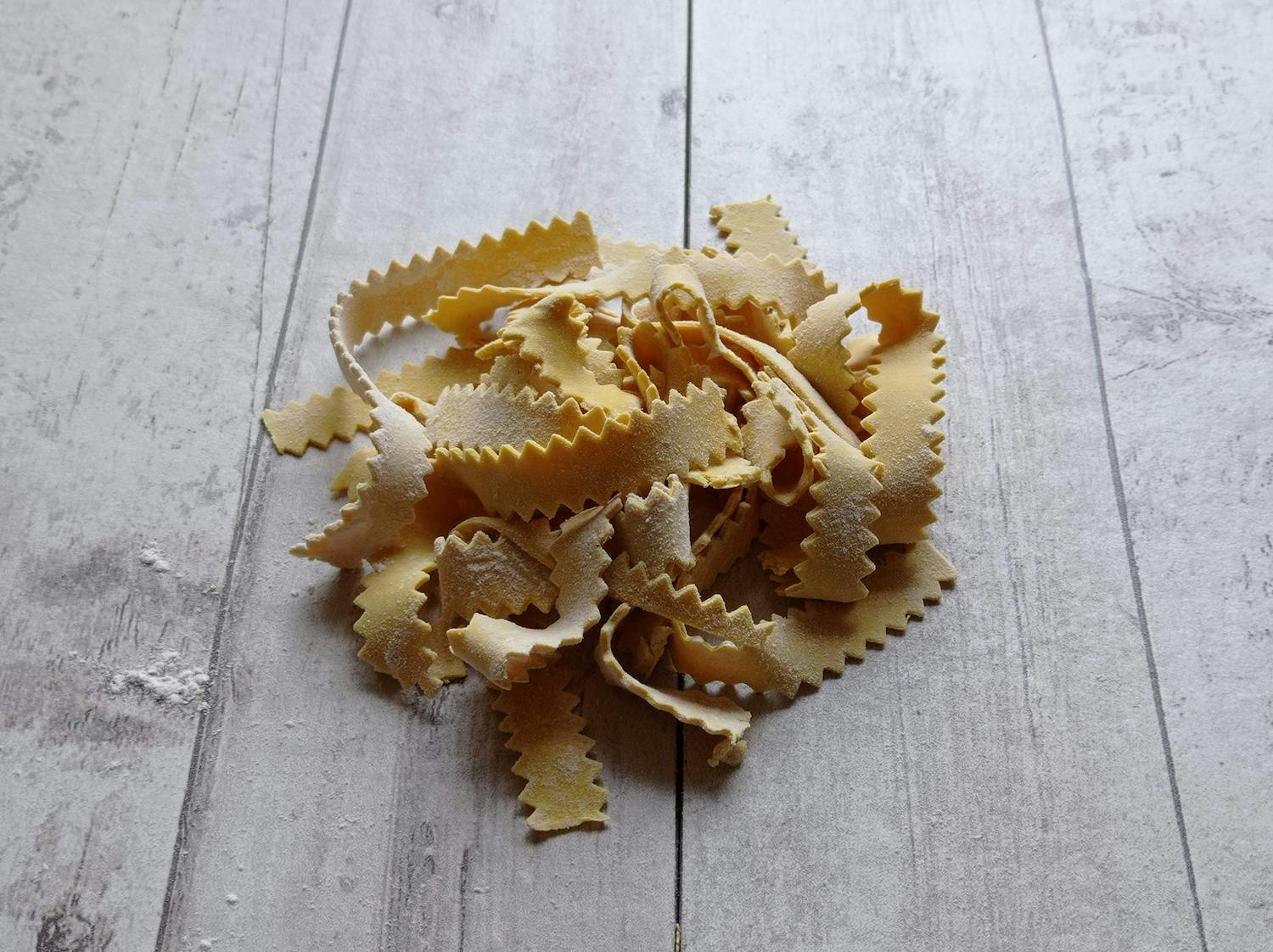 Homemade pasta strips on rustic wooden surface