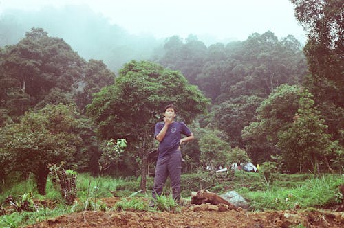 Man Standing on the Grass Smoking His Cigarette